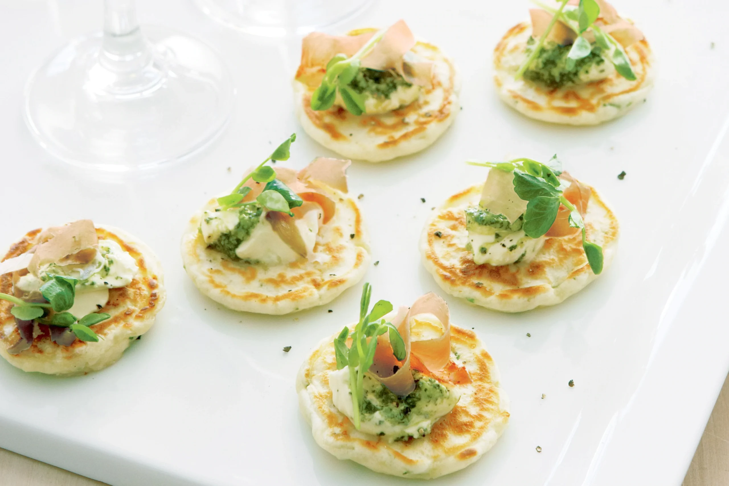 Freshly made blini batter being poured onto a hot griddle 