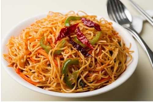 Chilli Garlic Noodles in a wok with red chili flakes 