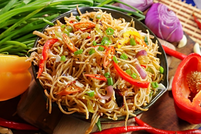 Steaming hot Chilli Garlic Noodles served with chopsticks 