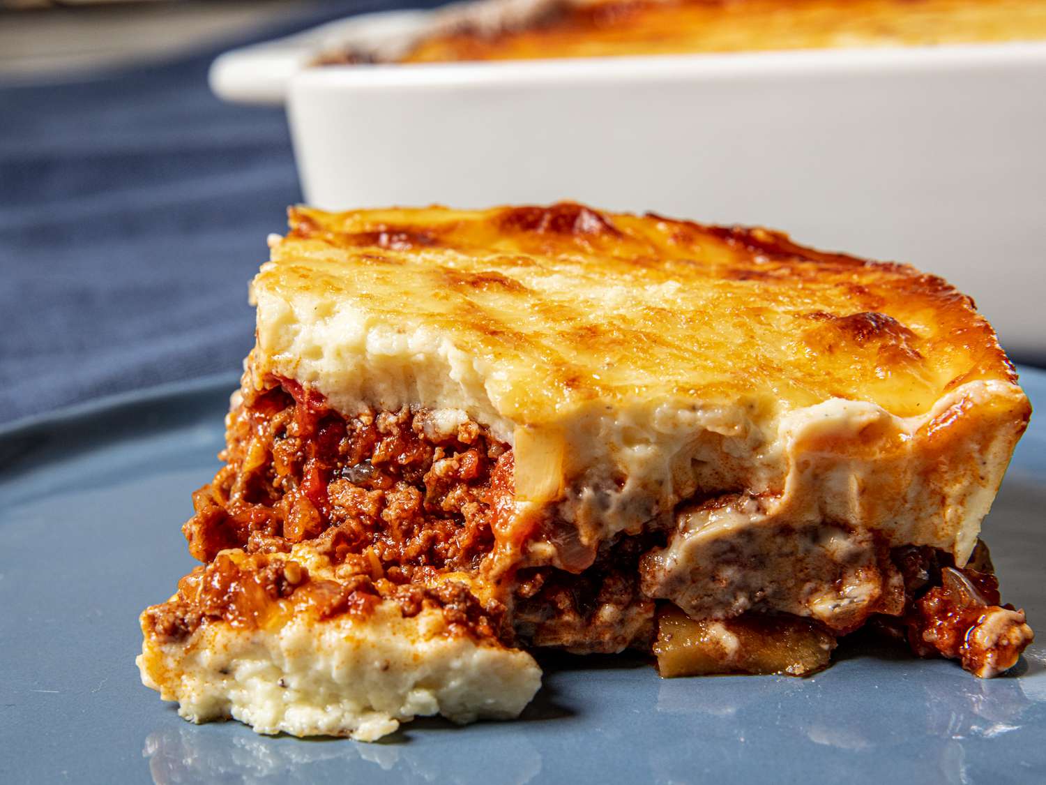 A plate of homemade moussaka garnished with fresh herbs 